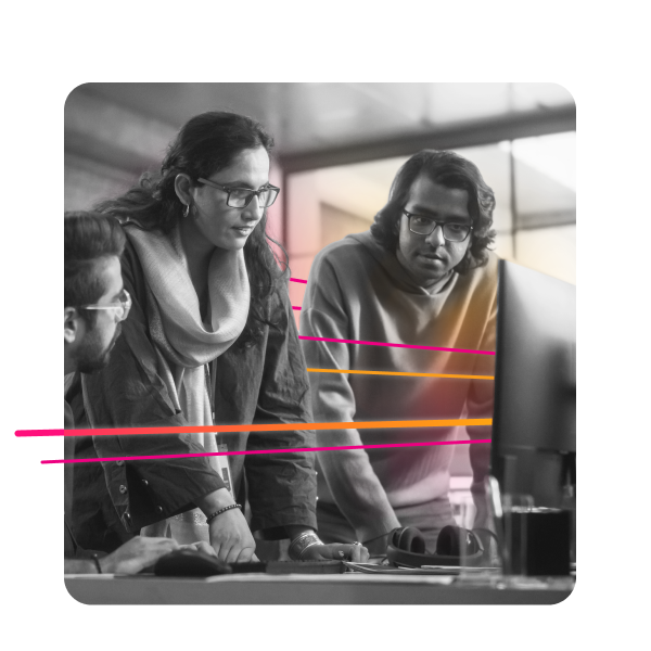 Three coworkers gather around a computer monitor.
